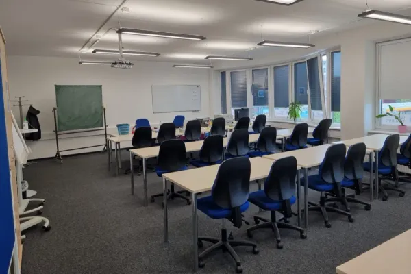 Seminarraum am Standort Hamburg mit Tischreihen und Tafel